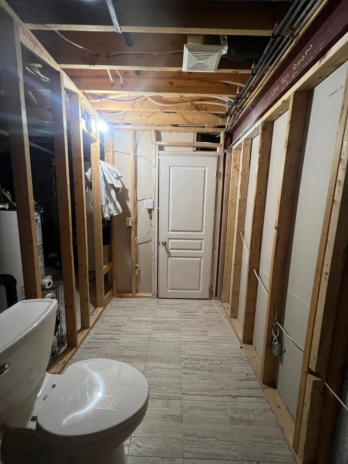 Bathroom during renovation showing exposed framing around the entrance