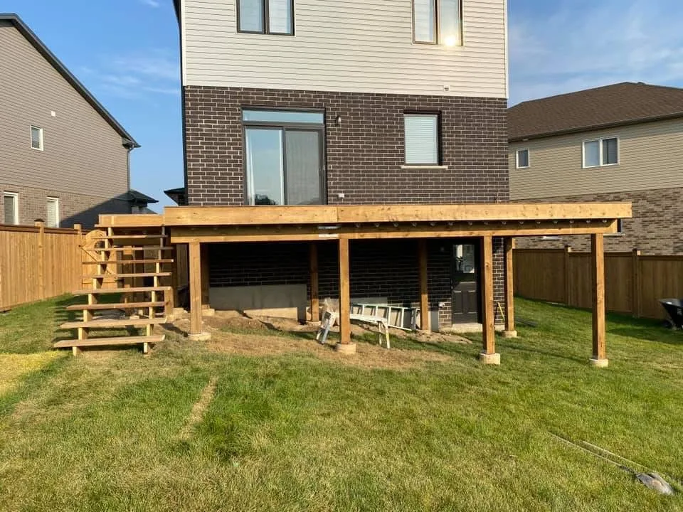 Wood deck structure with support posts and stairs before railings