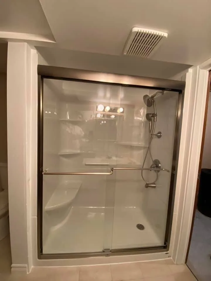 Shower enclosure with sliding glass doors after a walk-in tub conversion